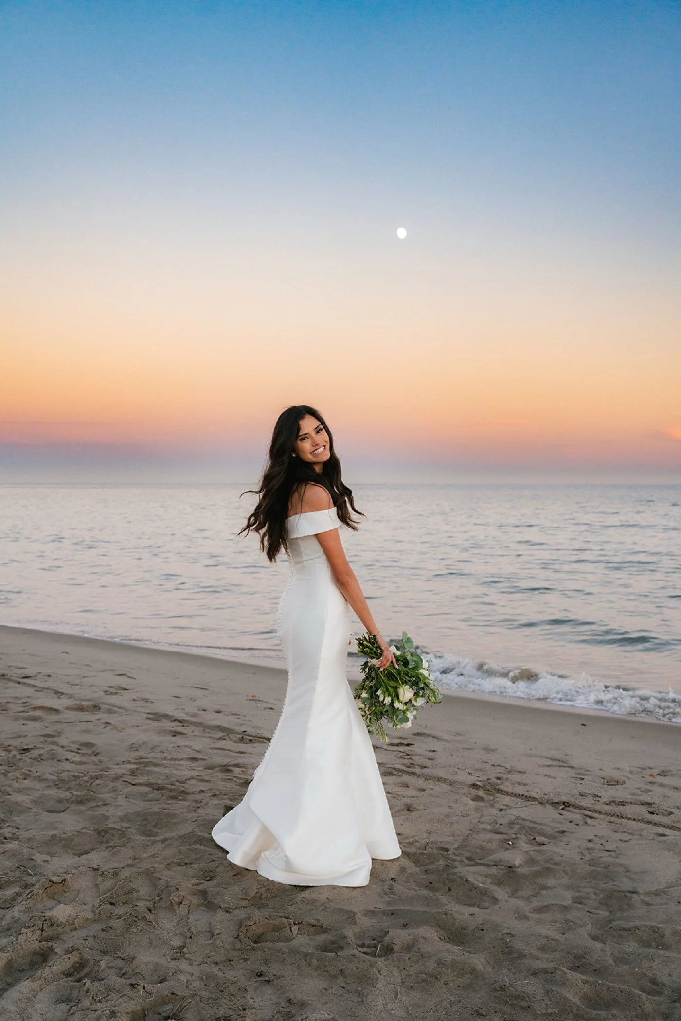 bride and groom taking portraits on the beach at their cabrillo pavilion wedding in santa barbara