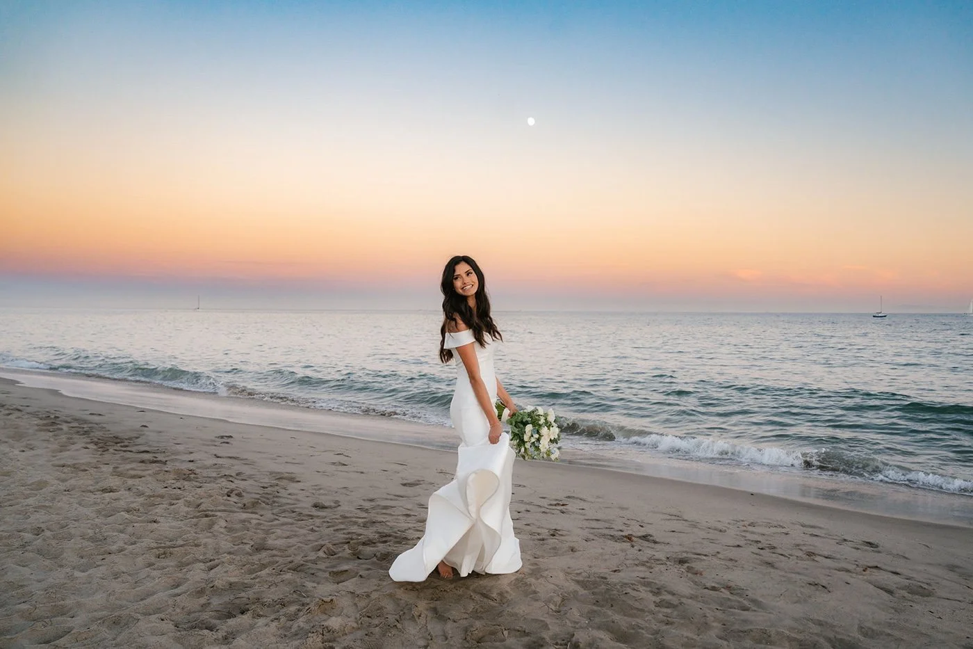 bride and groom taking portraits on the beach at their cabrillo pavilion wedding in santa barbara