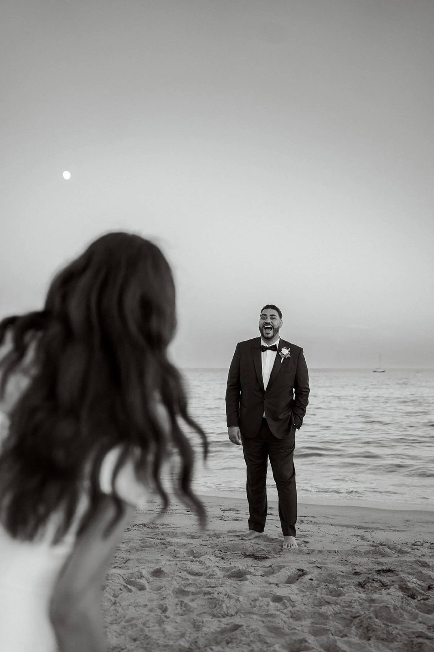 bride and groom taking portraits on the beach at their cabrillo pavilion wedding in santa barbara