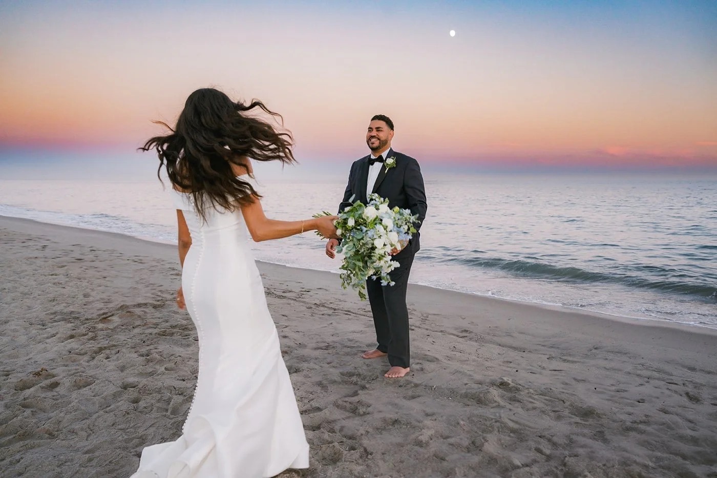 bride and groom taking portraits on the beach at their cabrillo pavilion wedding in santa barbara