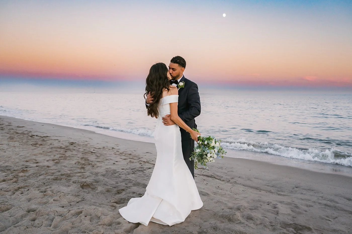 bride and groom taking portraits on the beach at their cabrillo pavilion wedding in santa barbara