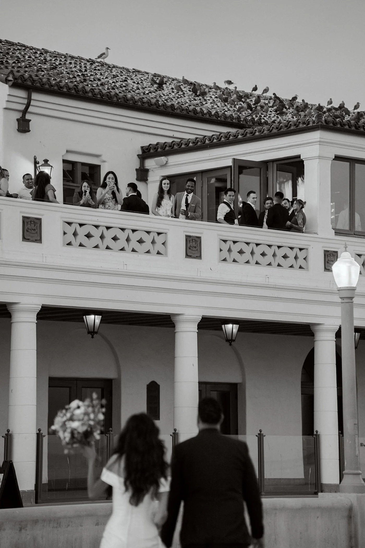 bride and groom taking portraits on the beach at their cabrillo pavilion wedding in santa barbara