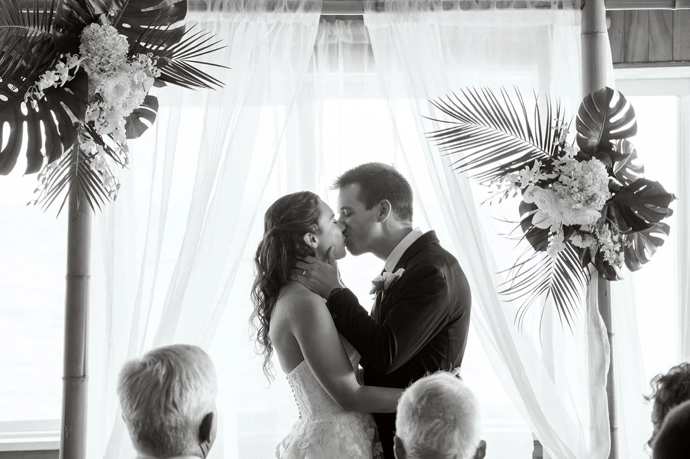 bride and groom sharing a first kiss at their wedding ceremony at duke's malibu
