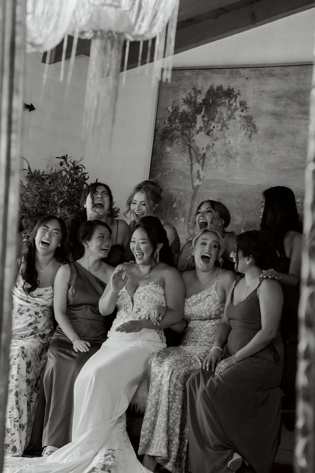 a bride and her bridesmaids laughing together on her wedding day in los angeles california