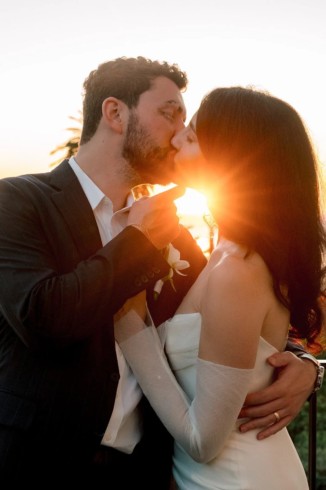 man and woman kissing at sunset on their wedding day in california
