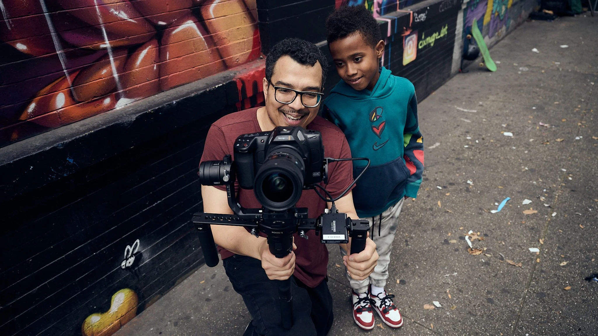 Director of photography Steven Tapia reviews footage with young Black skateboarder Talib on set in Brooklyn New York — behind the scenes production still from Pebbles Suck by Black Shutter Productions