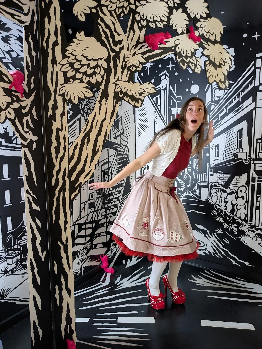 A woman in heels and puffy skirt gasps as she stares above her. It appears as though she has stepped into a comic or picture book.
