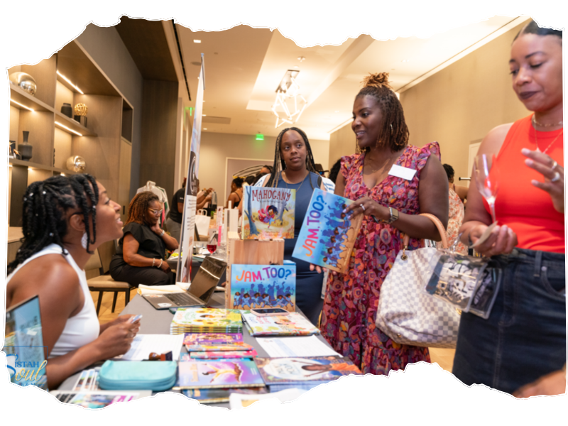 People browse books at an indoor event booth.