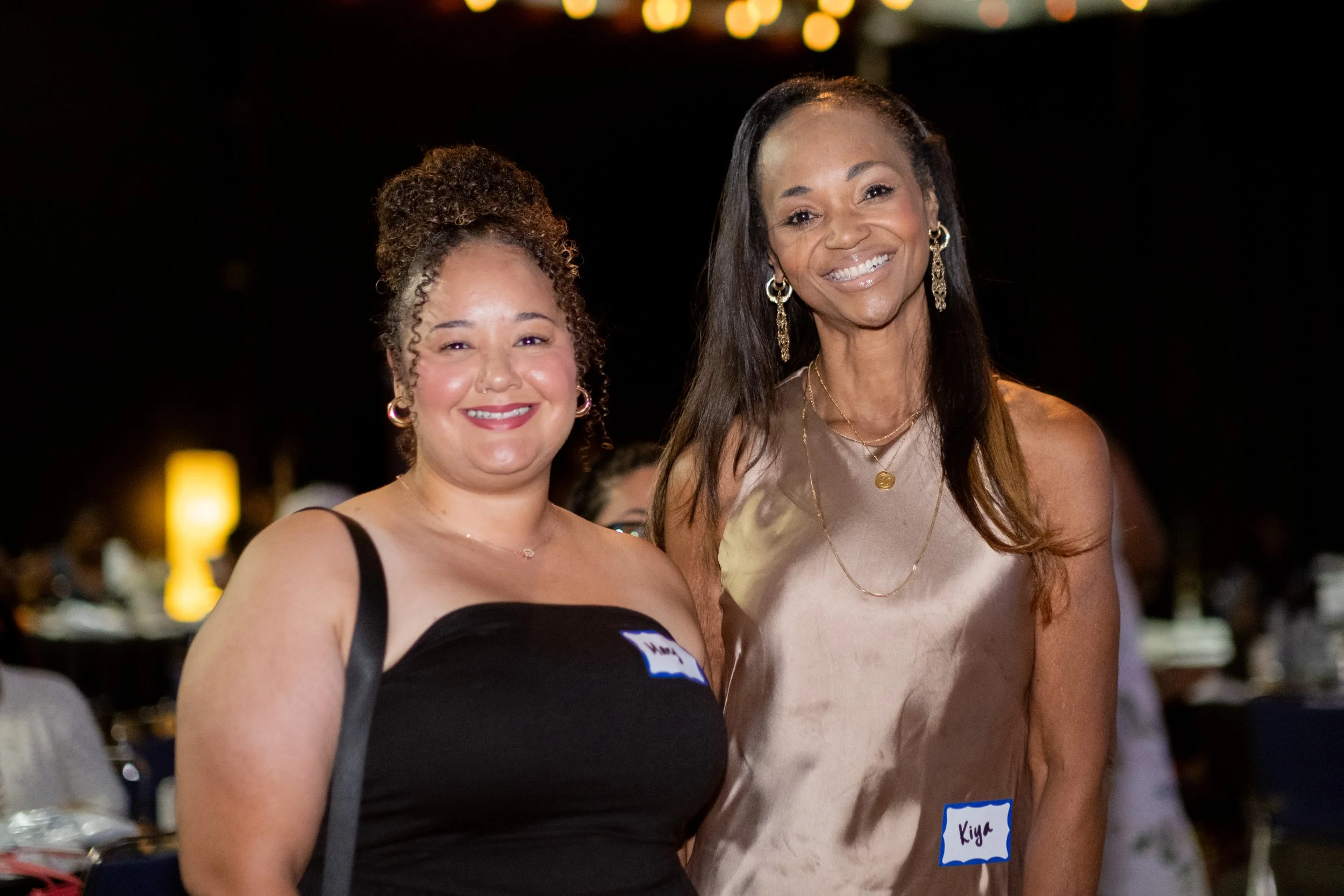 Two women smile for a photo at the event.