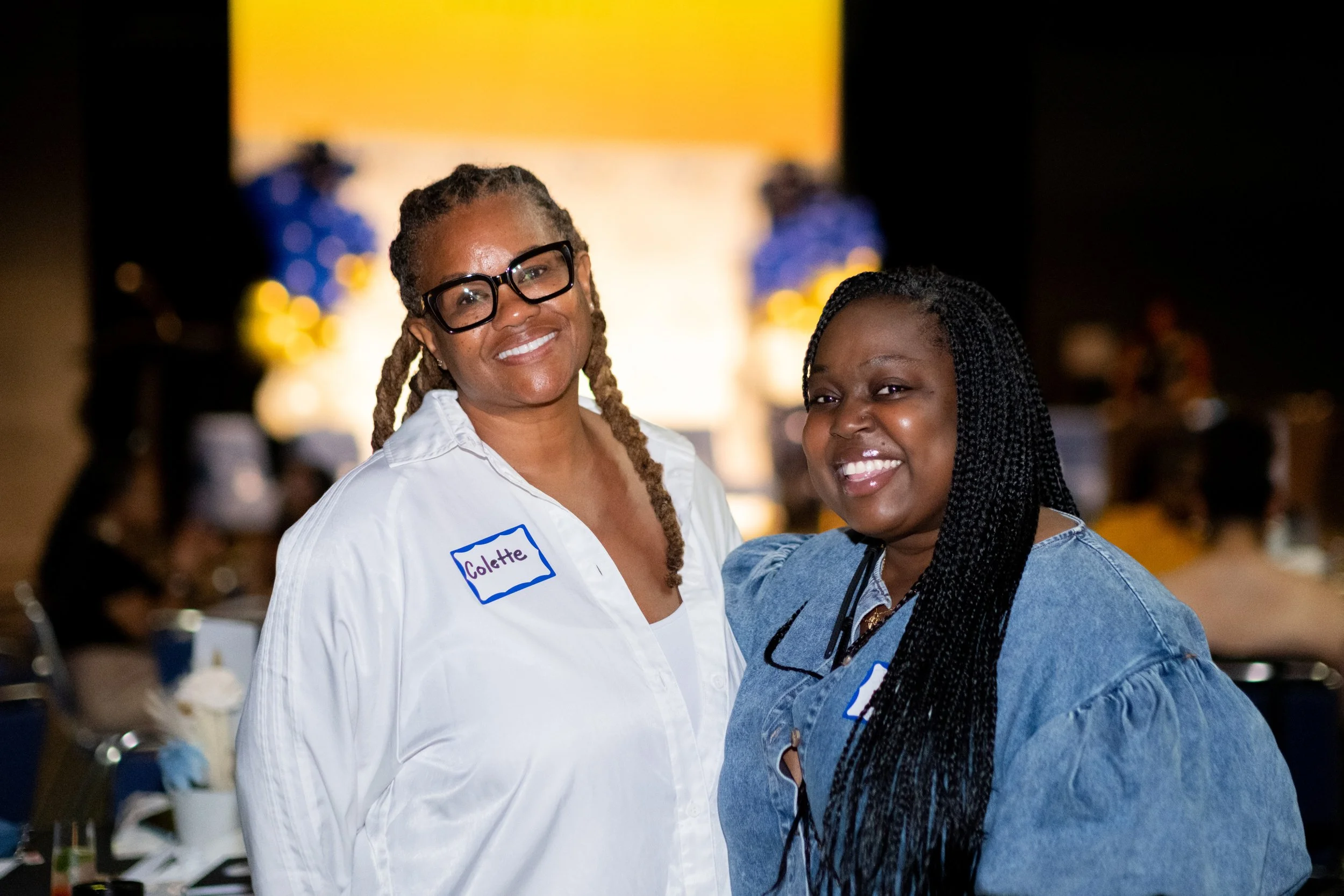 Two women smile together while attending the event.