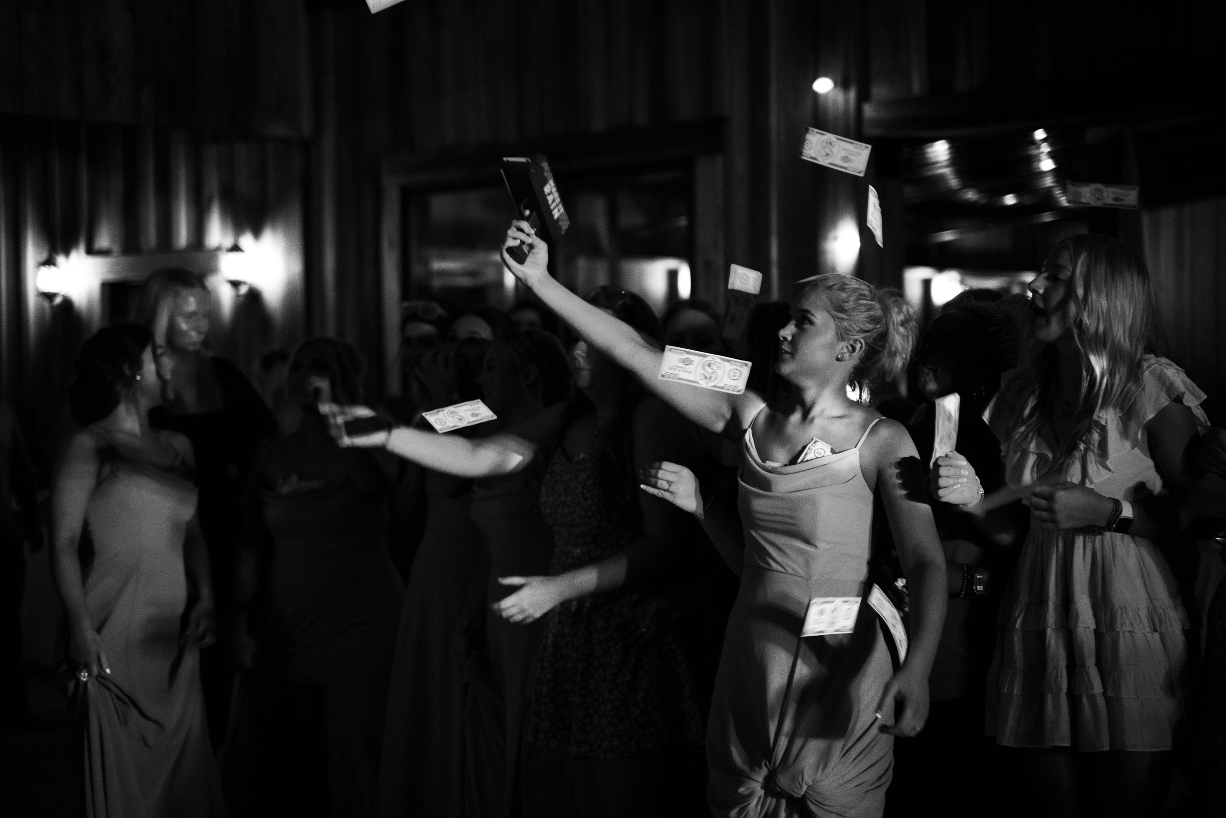Women on a dance floor throwing money in the air at an event or celebration.