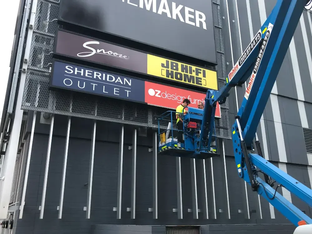 Outdoor shopping centre signage being installed