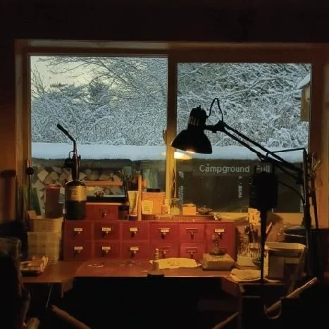 A close up of a silversmith soldering together a fine silver bezel for sea glass to sit in.