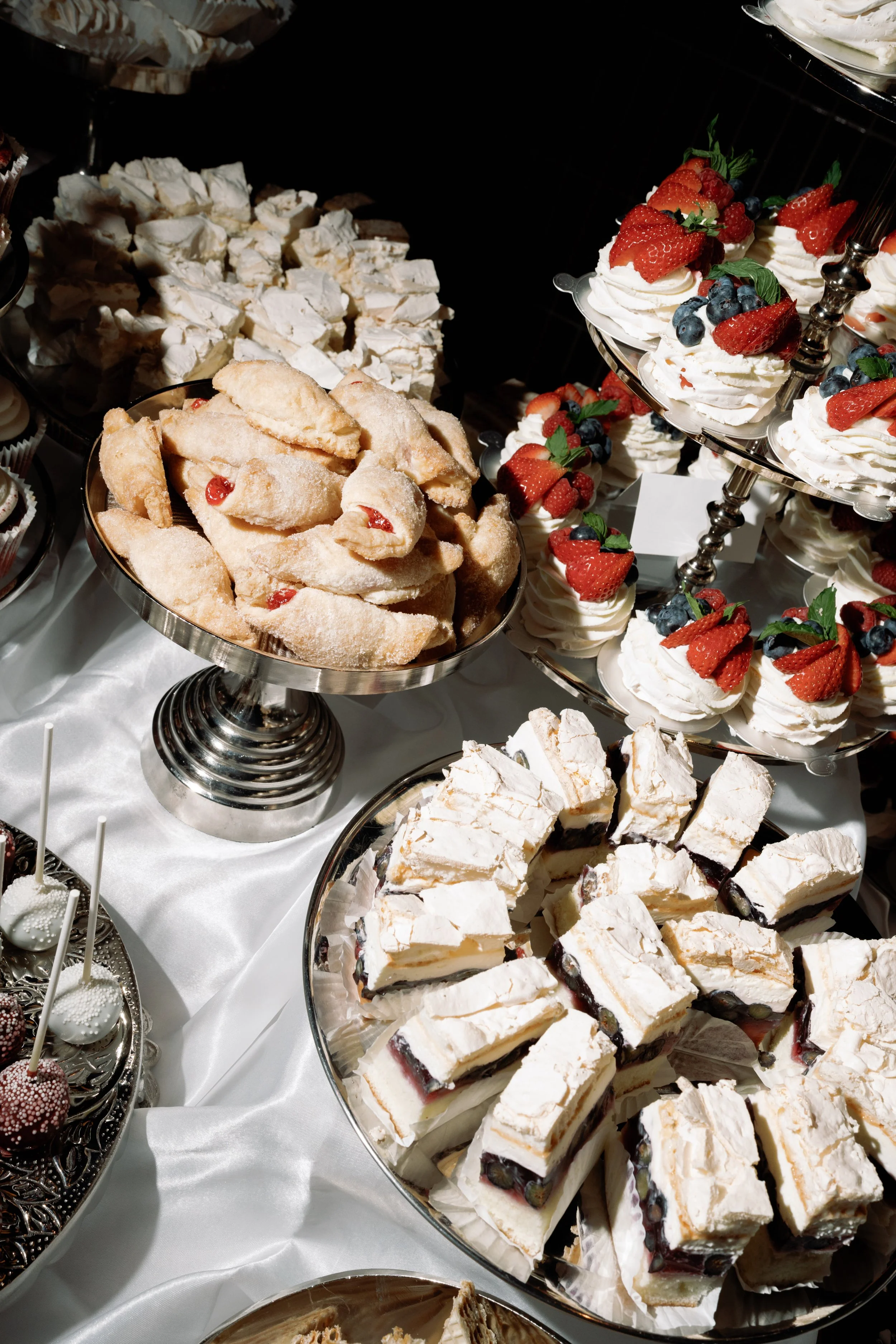 Fruit tarts, hand pies, and meringue bars fill the reception dessert table