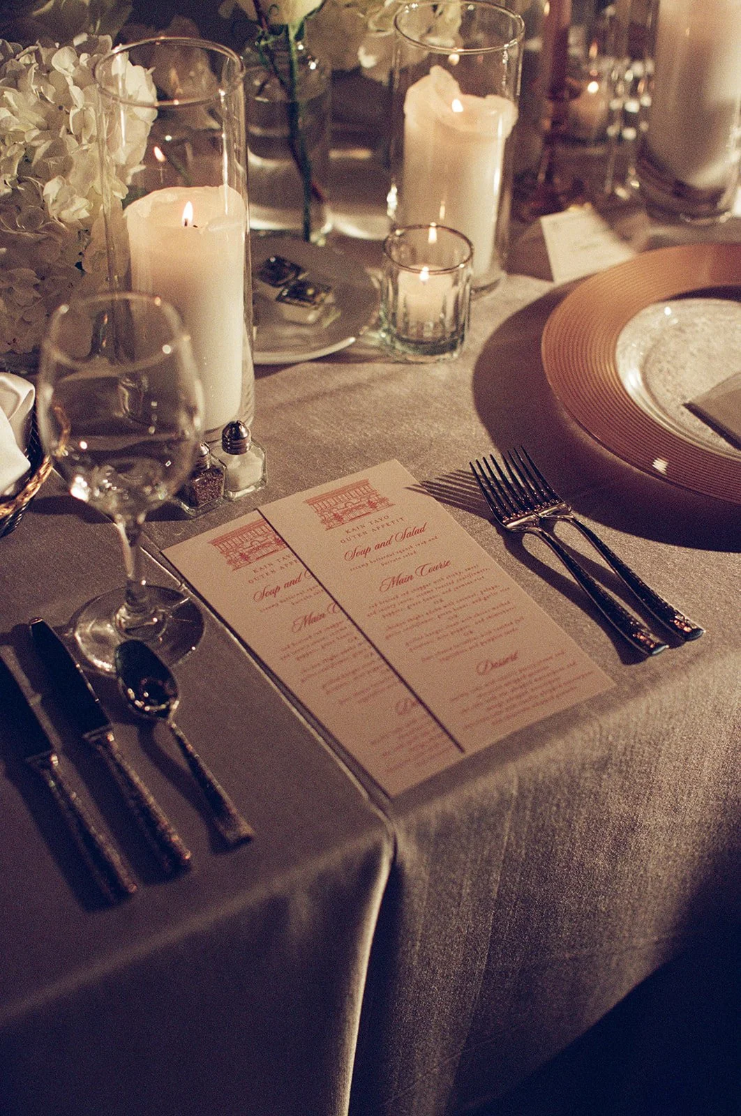 A detailed view of the reception place setting with printed menu card and gold decorative elements. Shot on film by a Chicago wedding photographer.