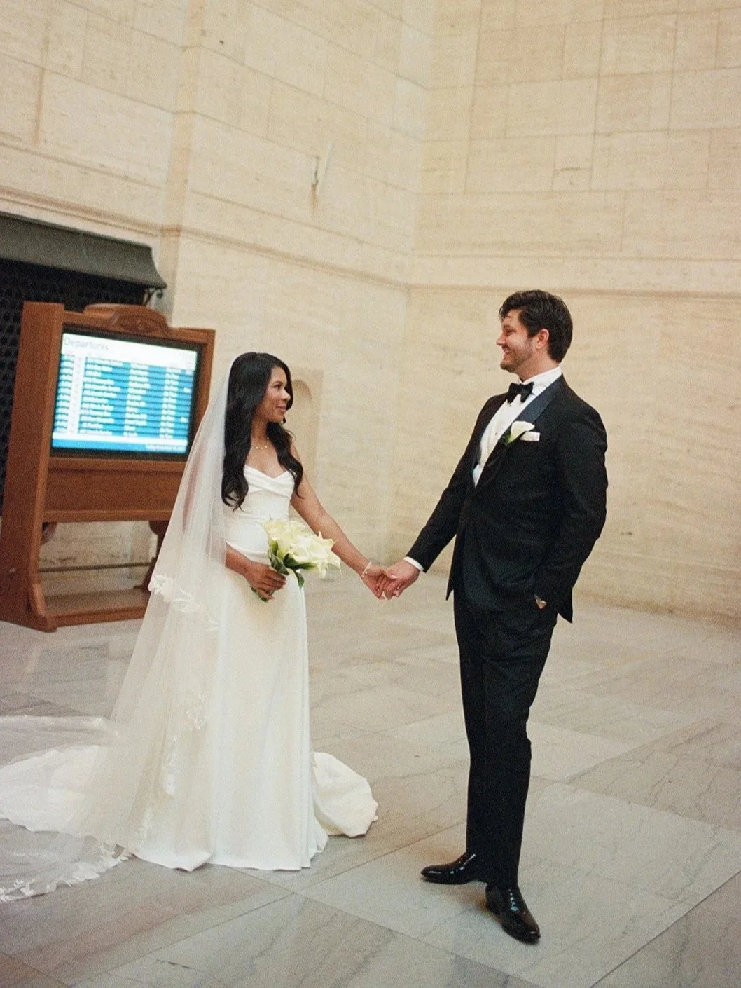 Sarah and Brennan hold hands in Chicago's Union Station, photographed on film