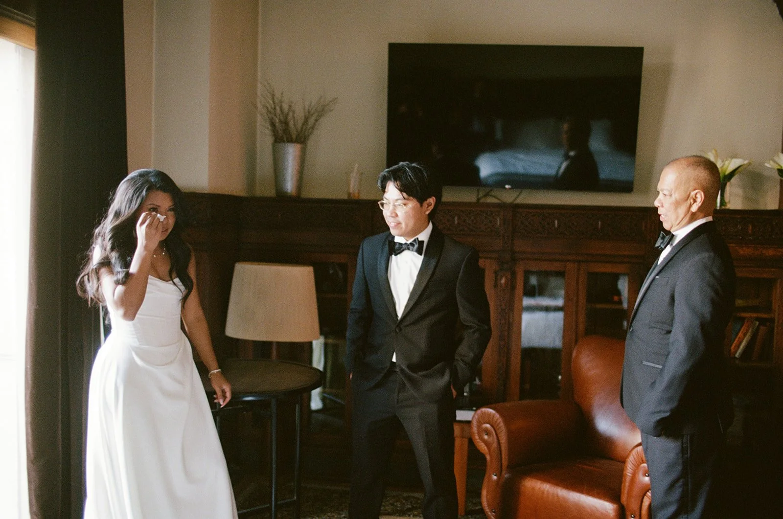 Sarah and Brennan with family members in an intimate moment in the elegant room at Chicago Athletic Association. Shot on film by a Chicago film wedding photographer.