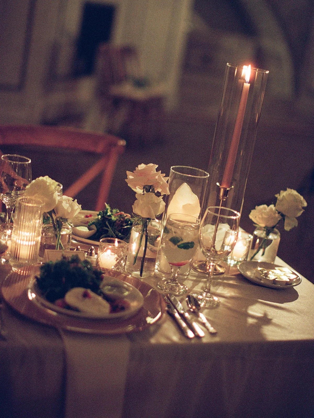 A detail shot of the reception table centerpiece with white blooms and elegant tall taper candles. Shot on film by a Chicago wedding photographer.