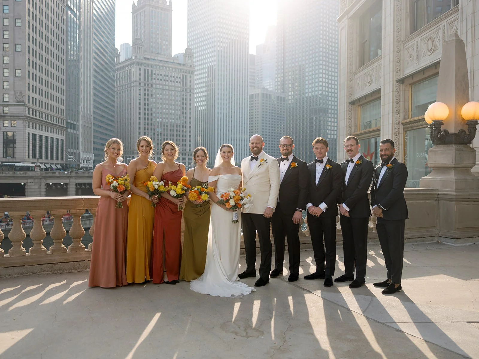 Bridal party in mismatched warm-toned gowns, radiating joy and effortless color coordination.