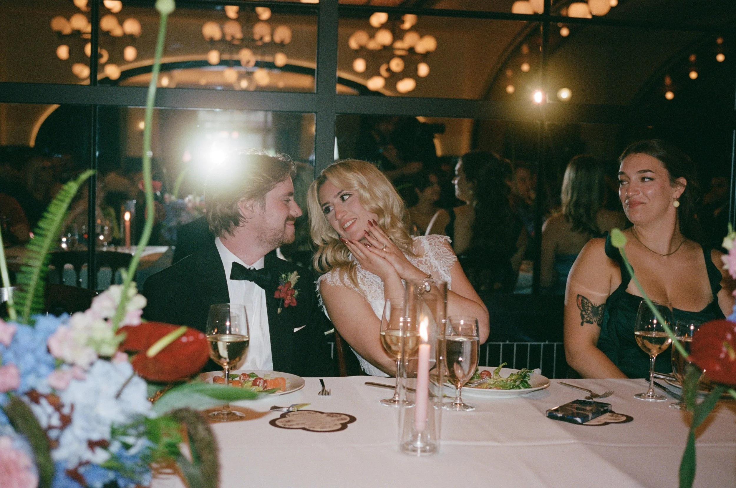 Bride and groom laugh together at their candlelit reception table