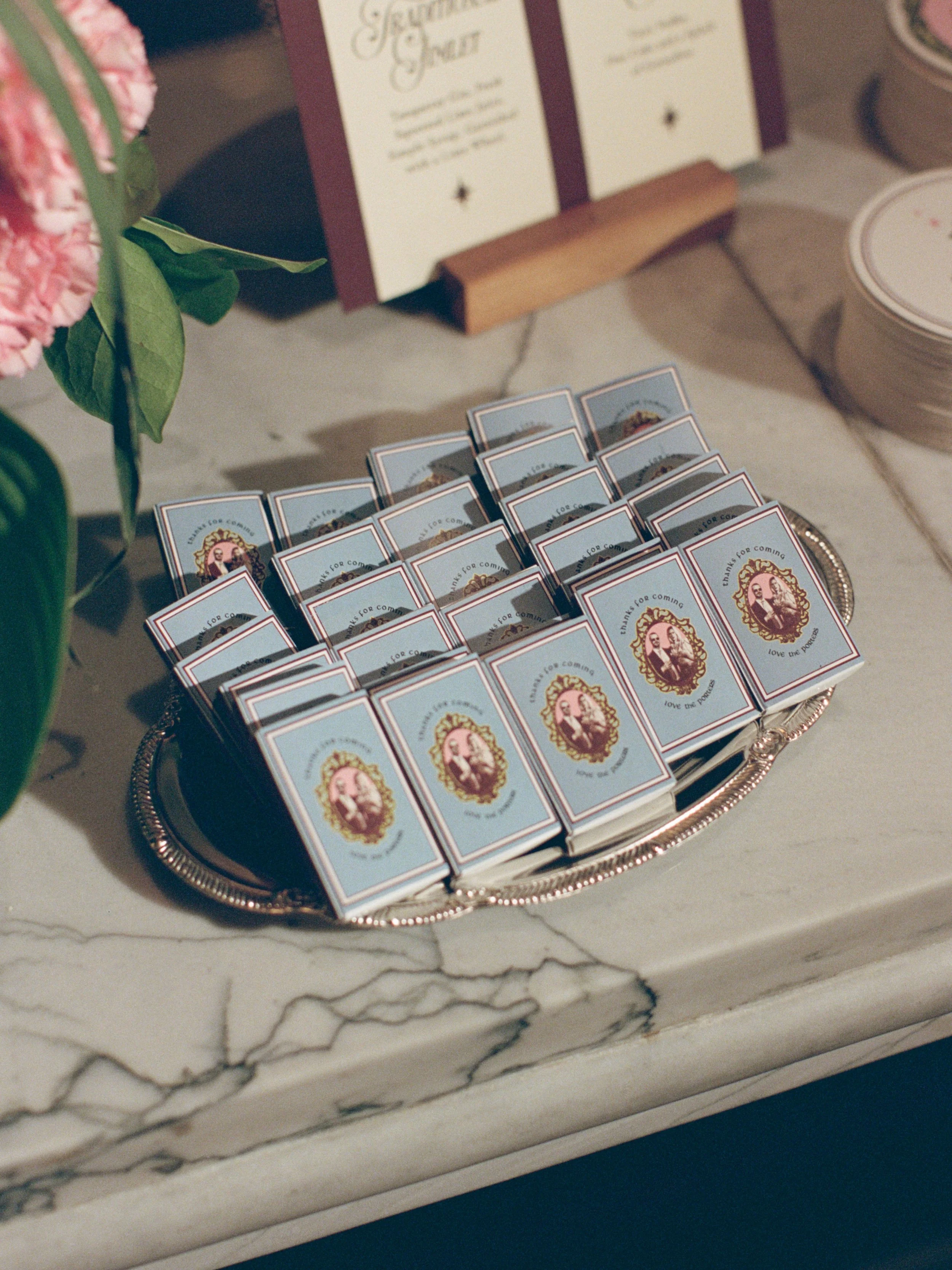 Rows of wrapped wedding favor boxes displayed on a silver tray