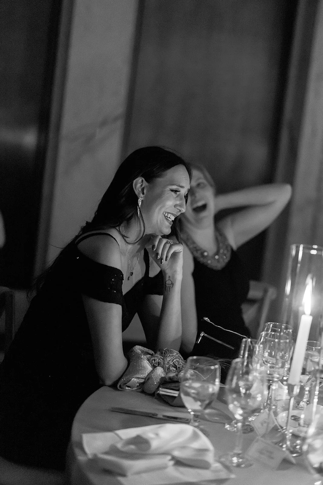A joyful candid of a wedding guest in a burgundy satin gown laughing during the reception. Shot on film by a Chicago wedding photographer.