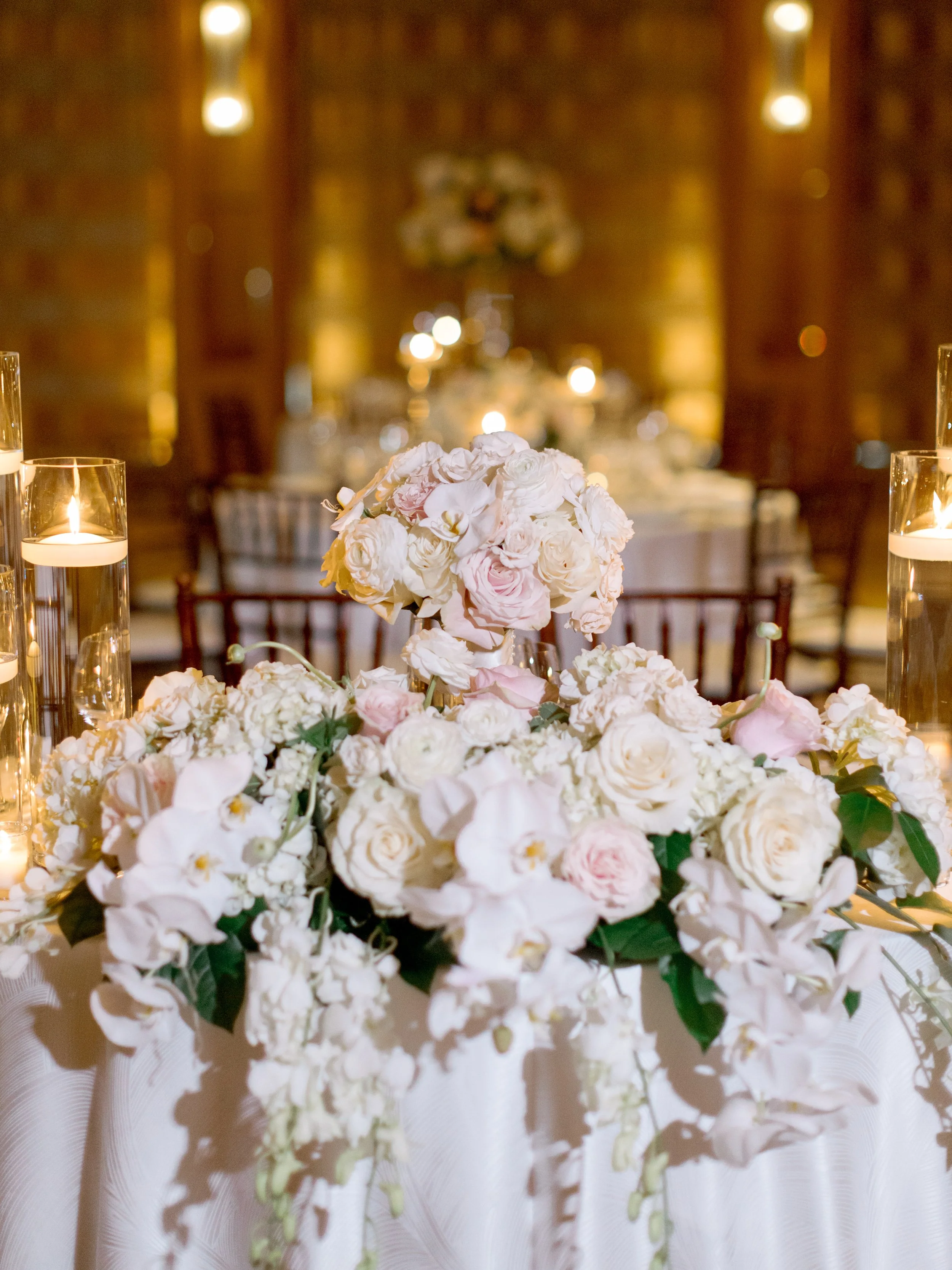 Sweetheart table at The Peninsula Chicago reception with blush florals, candles and a champagne bucket, film photography