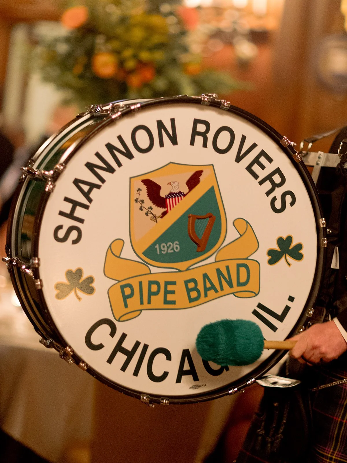 A close-up of the Shannon Rovers Pipe Band bass drum — the vintage 1926 Chicago emblem front and center, mallet poised. A nod to the couple's Irish heritage and one of the most memorable entertainment moments of the night