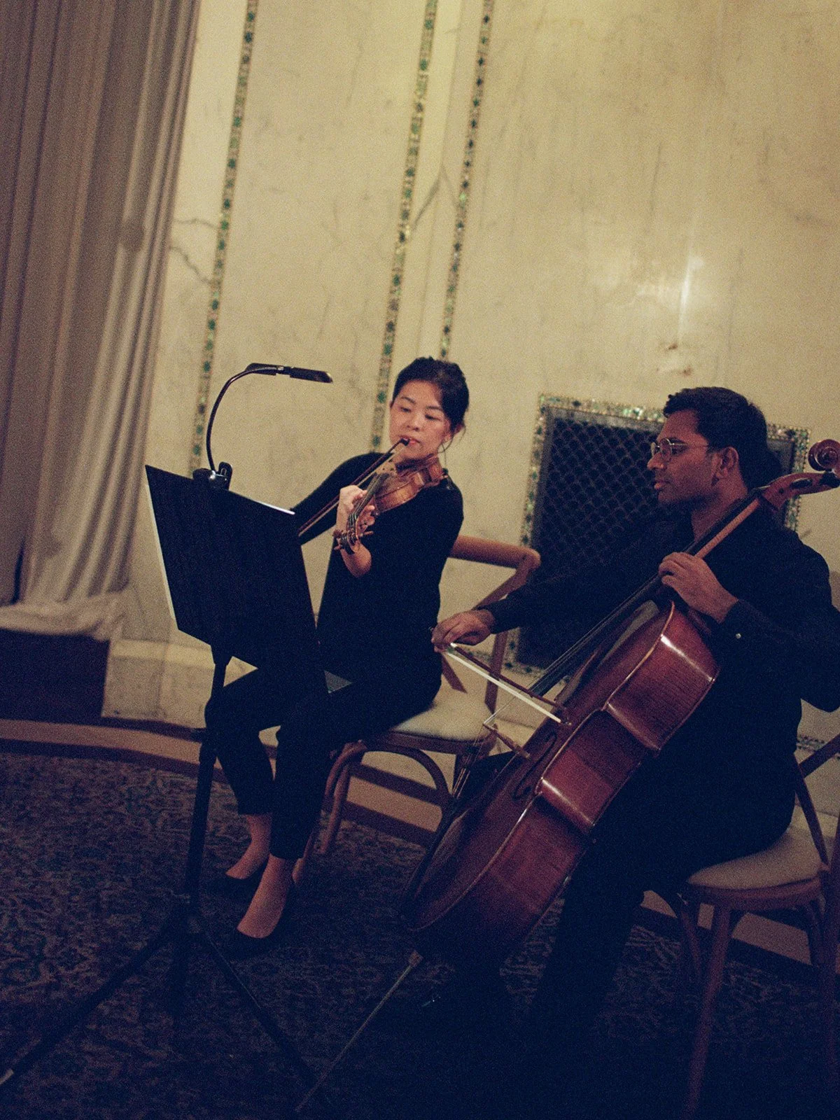 Musicians playing a violin and a cello as guests take their seats at the Chicago Cultural Center