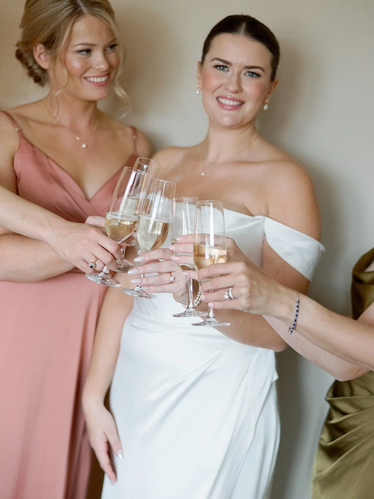 The bride and her bridesmaids raise their champagne flutes in a getting-ready toast — sparkle, smiles, and the kind of anticipation you can feel through the frame. Shot on film by a Chicago film wedding photographer.