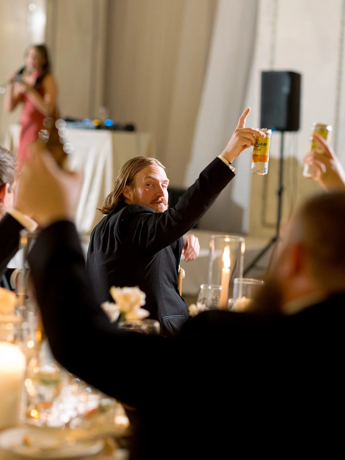 A wedding guest raising his glass in a heartfelt toast during the reception dinner, surrounded by candlelight and warm ambiance. Shot on film by a Chicago wedding photographer.