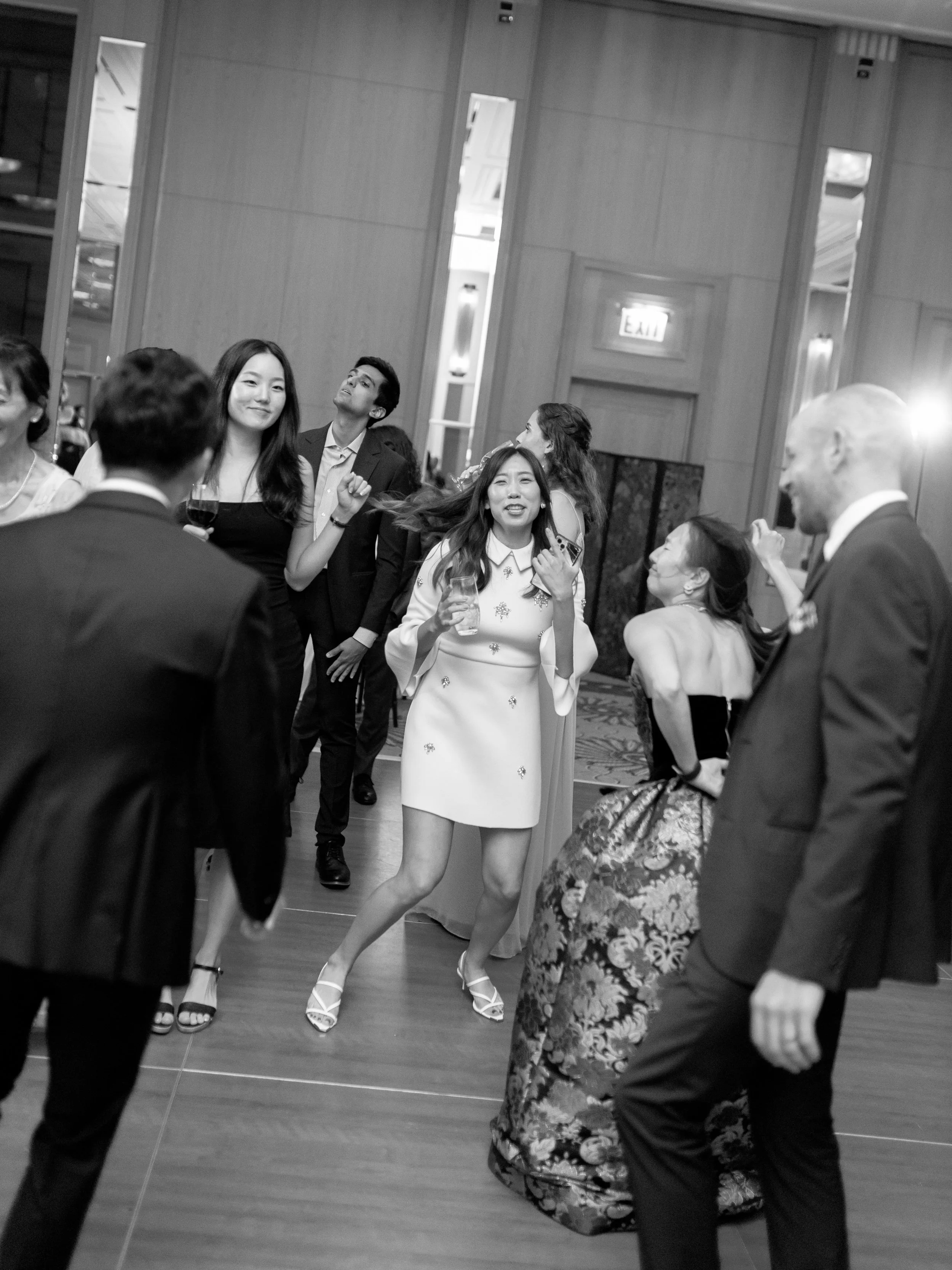 Black and white reception photograph of friends dancing and laughing on the Peninsula Chicago dance floor