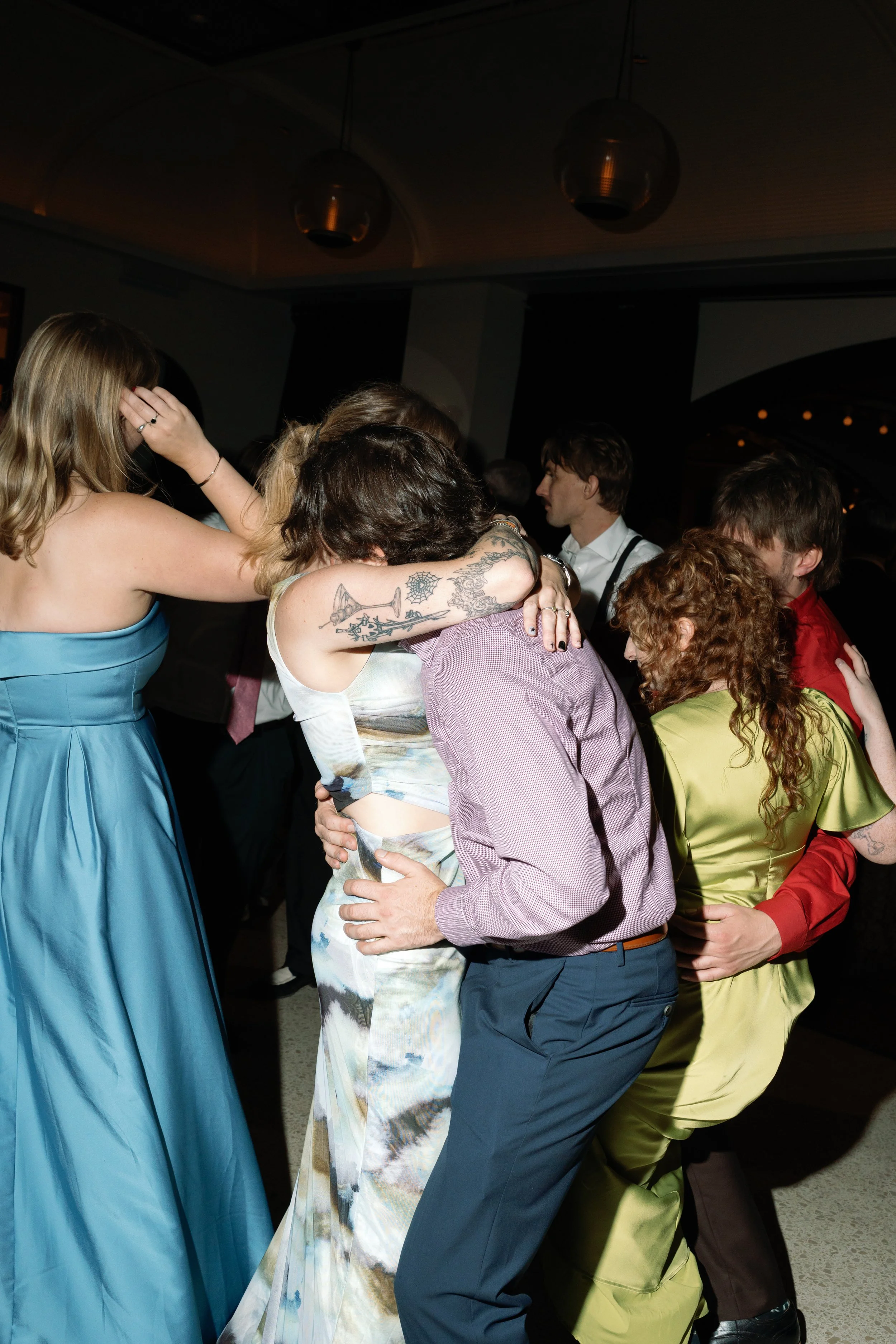 Guests share a group hug while dancing at the reception