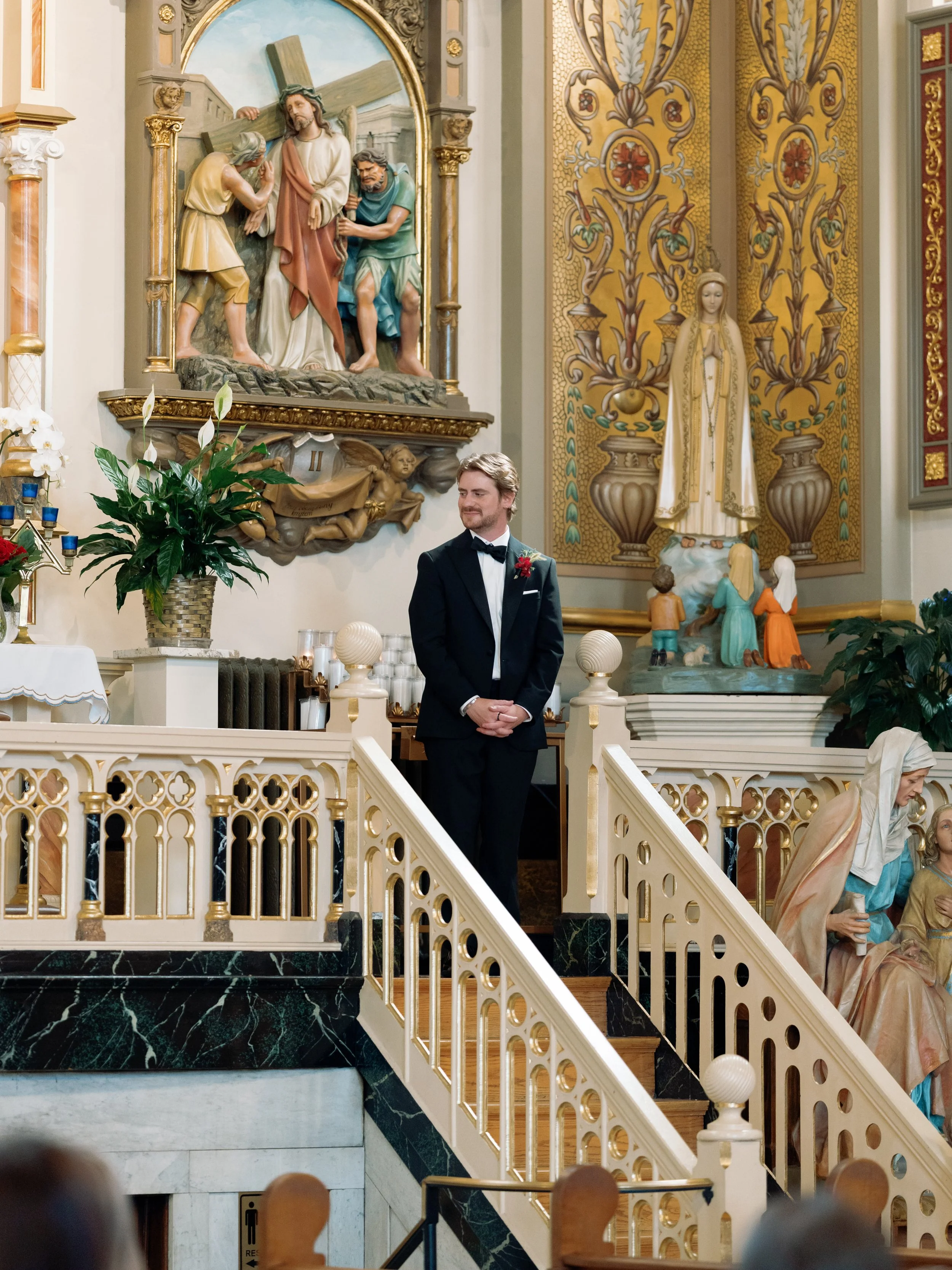 Groom waits alone at the altar beneath the church's gilded mural before the ceremony