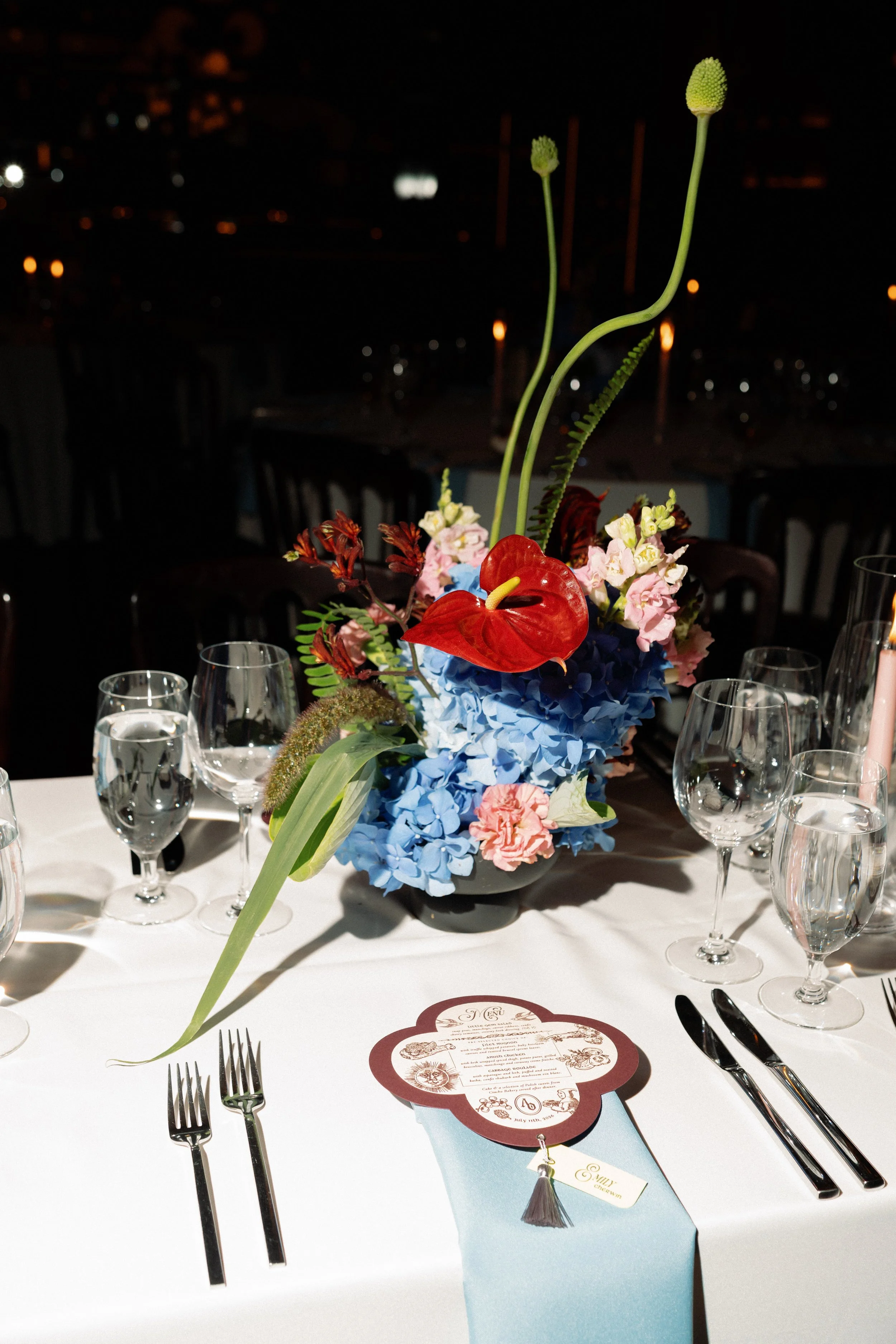 Blue hydrangea centerpiece glows in candlelight at the nighttime reception