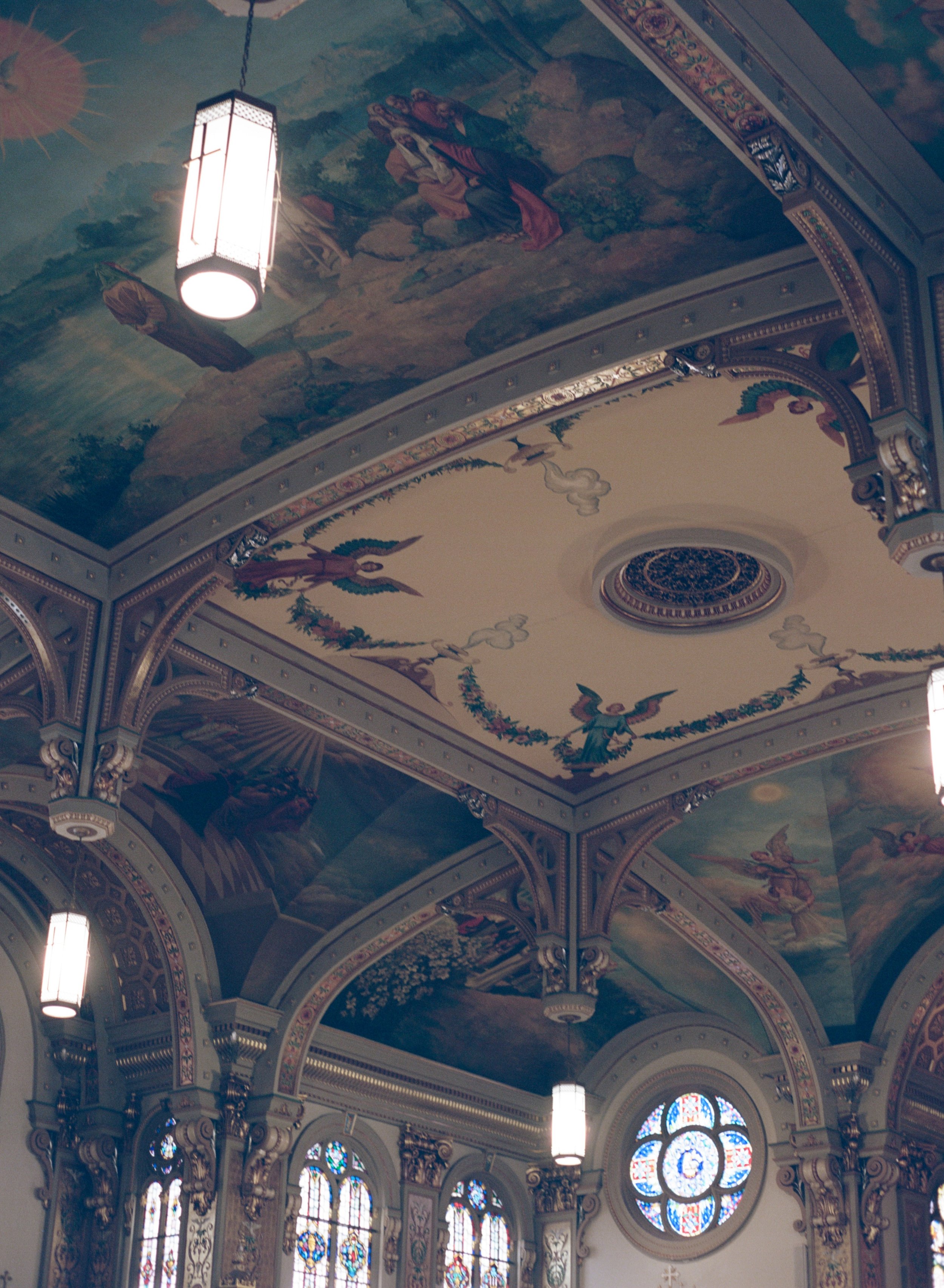 Detail of the church's painted ceiling murals and stained glass rosette window