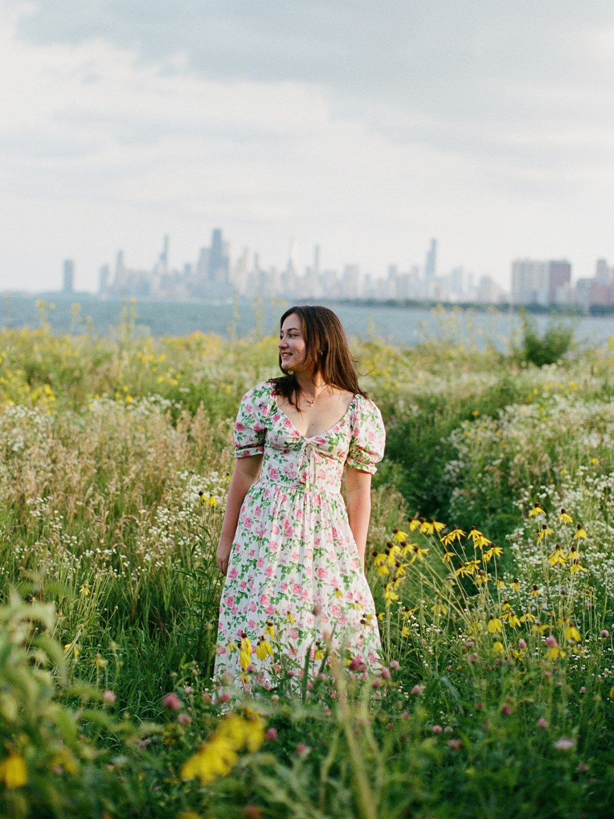 a woman posing in a field in front of the chicago skyline