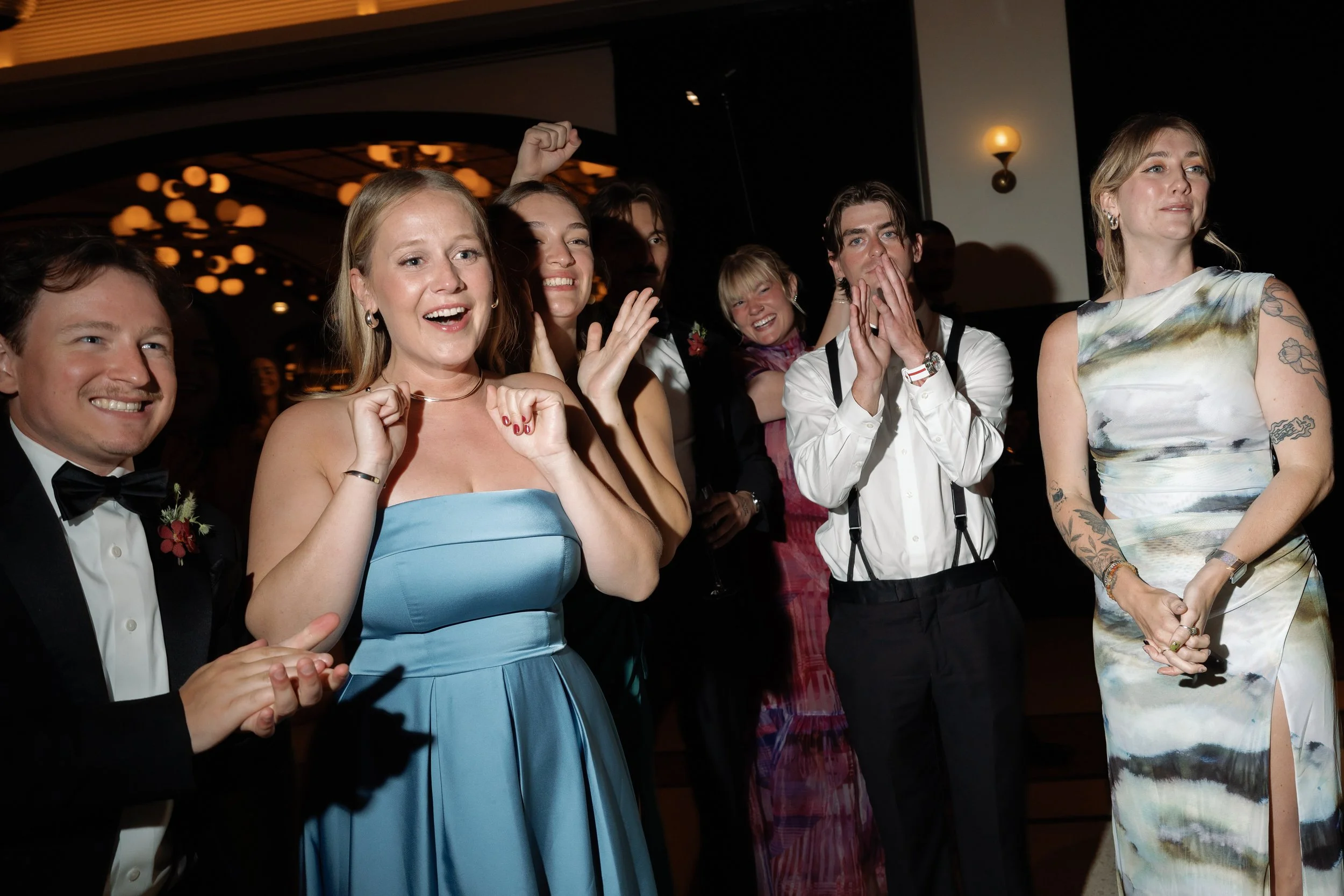 Guests cheer and dance together in a circle at the reception