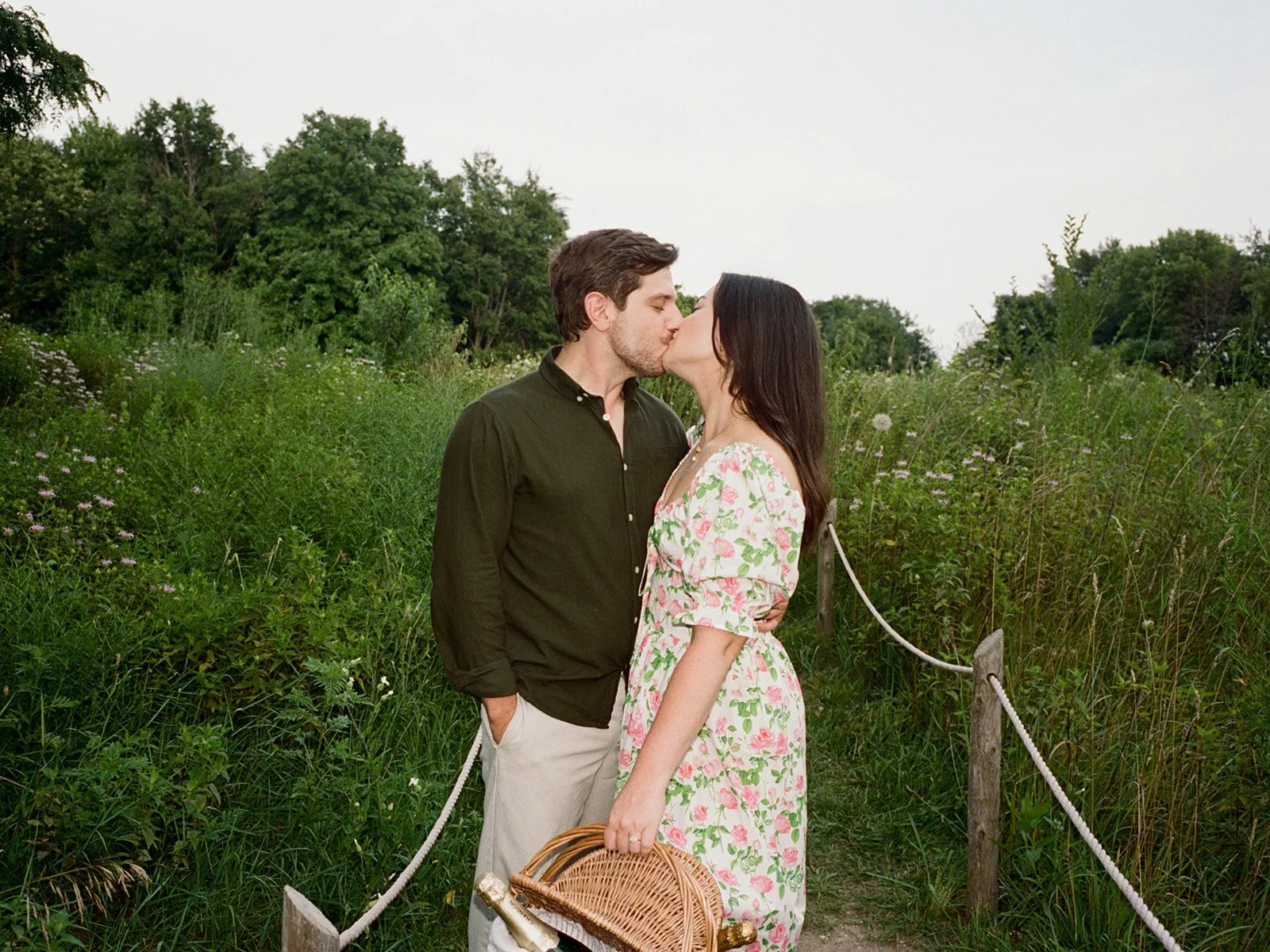 couple kissing in a field during their engagement session