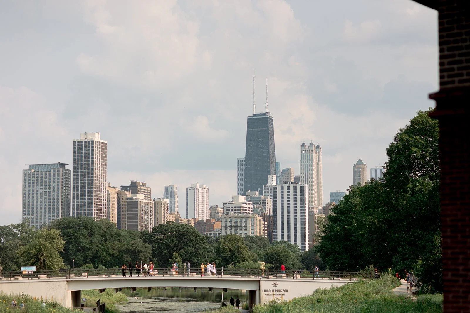 Sweeping view of the Chicago skyline from Lincoln Park lagoon near Cafe Brauer, John Hancock Center rising above the trees.