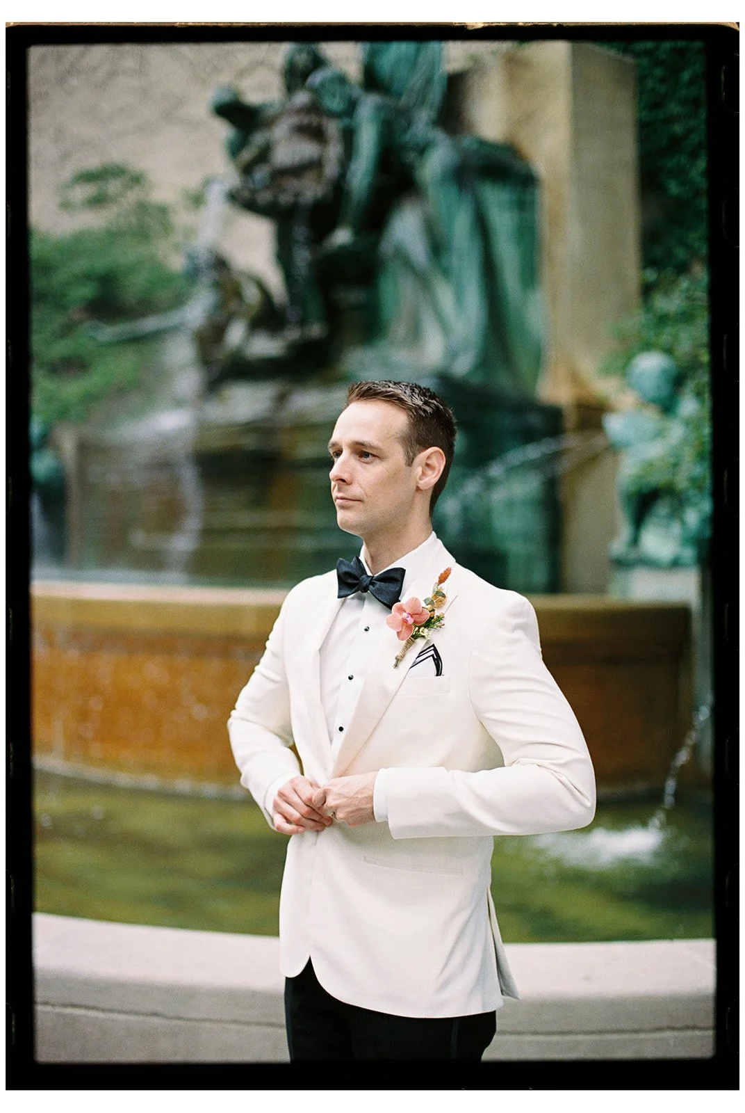 Film portrait of a groom in a white dinner jacket at the Art Institute of Chicago South Gardens, photographed by Chicago film wedding photographer Louie.