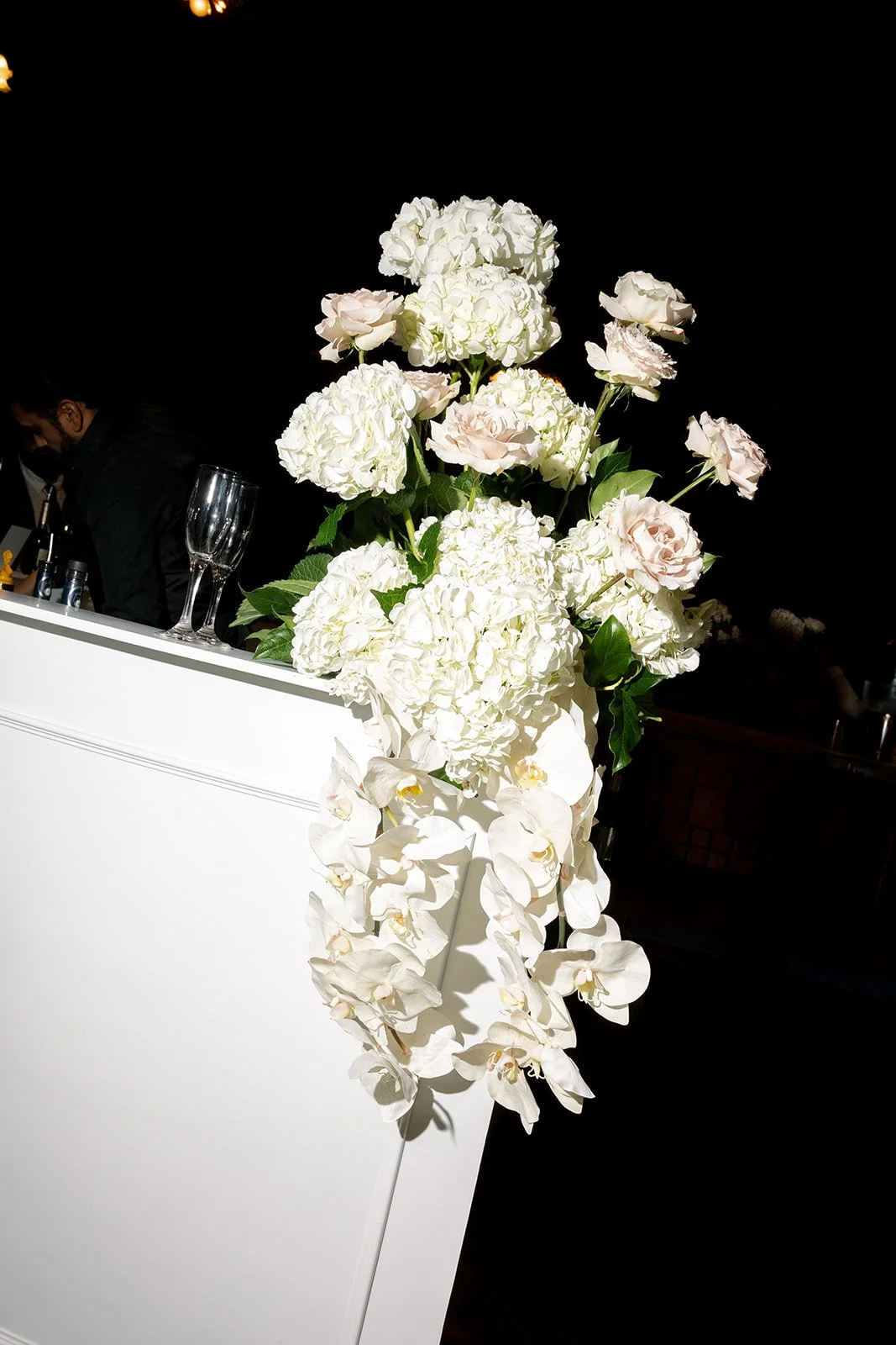 A bright flashed photo of a floral arrangement at the bar during the reception at the Chicago Cultural Center