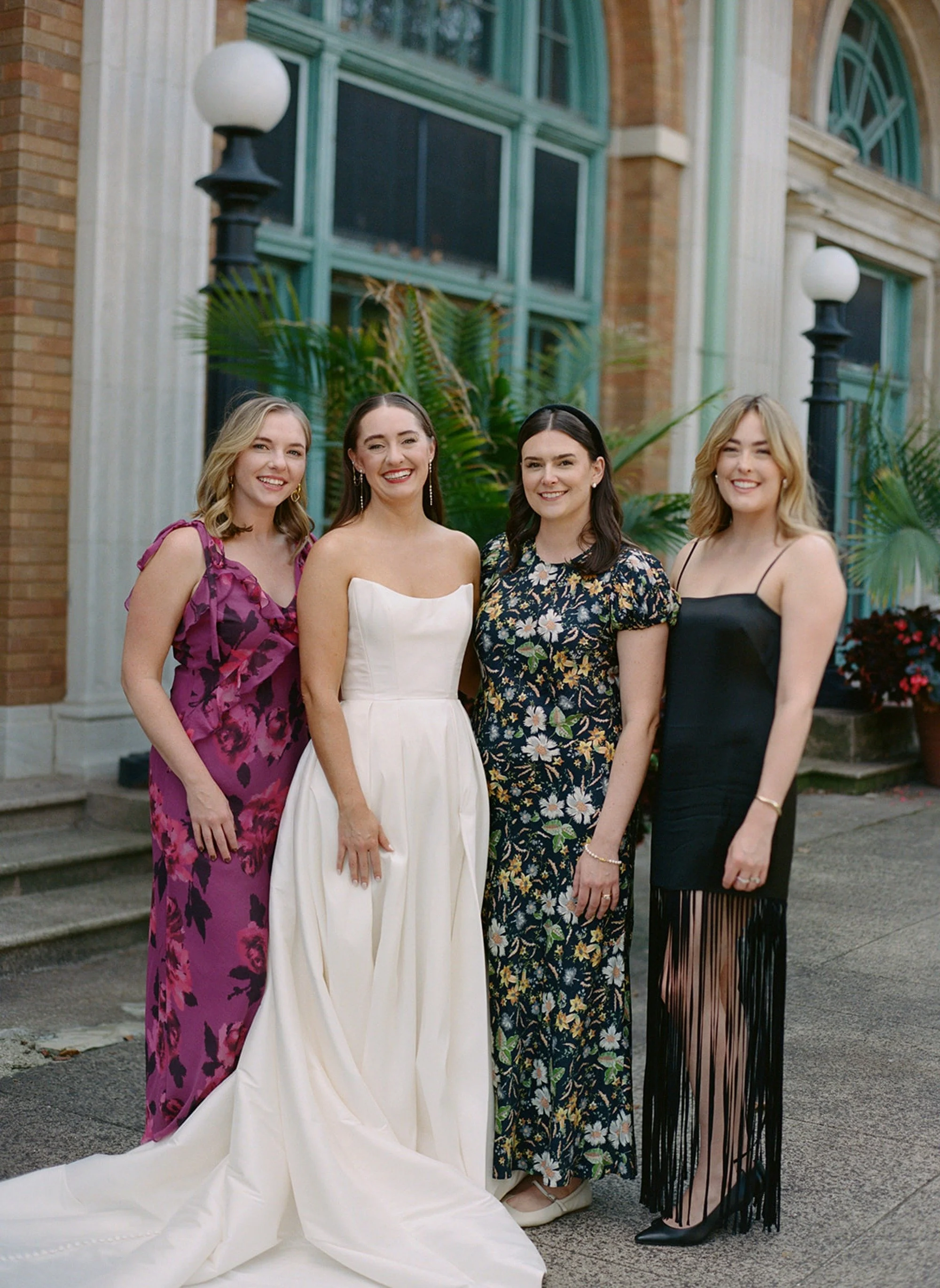 All smiles — the bride and her women in a natural, glowing group portrait outside Columbus Park Refectory. Colorful, joyful, and effortlessly styled