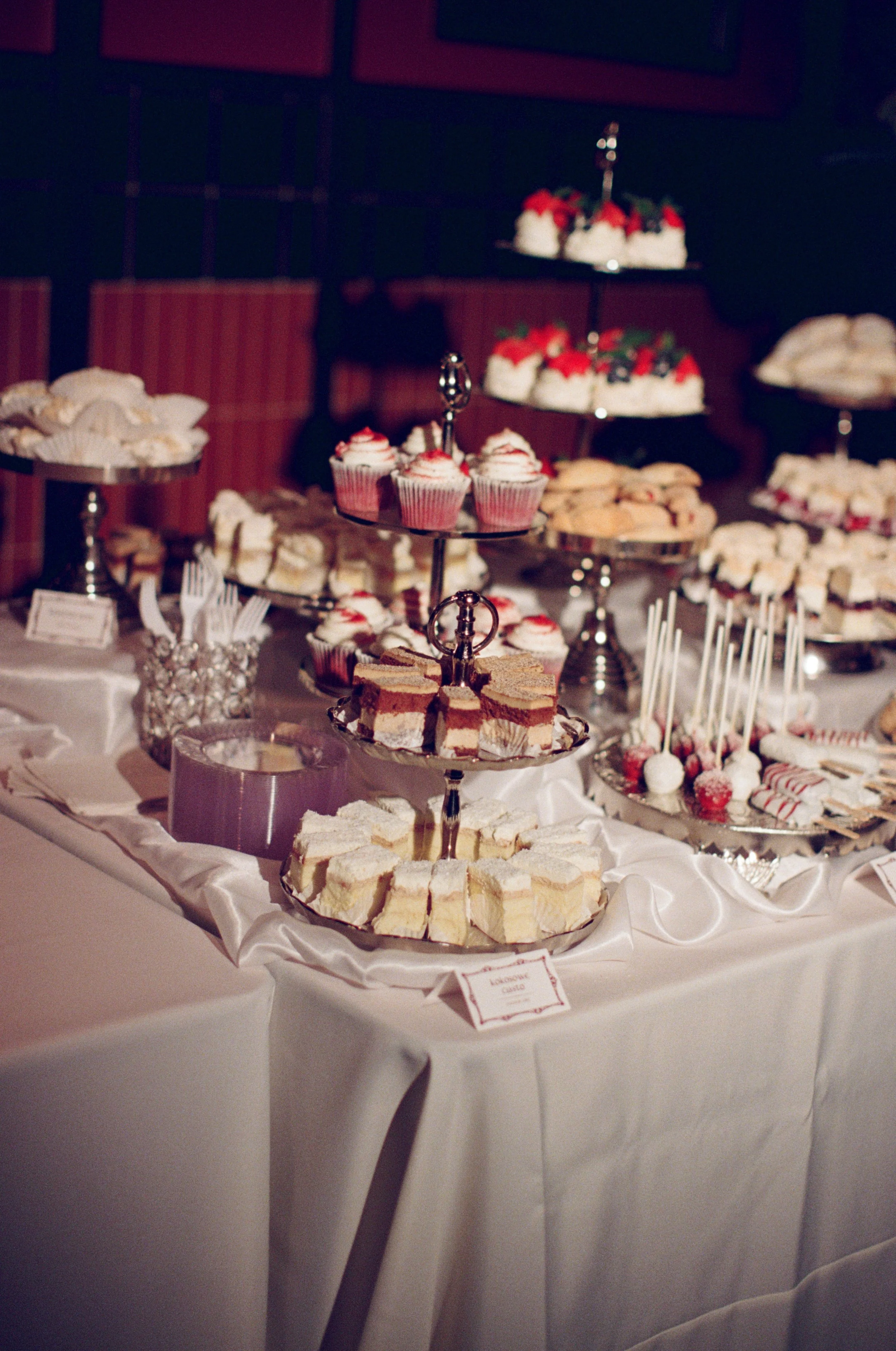 Black and white wide shot of the dessert table with cupcakes, cake pops, and cookies