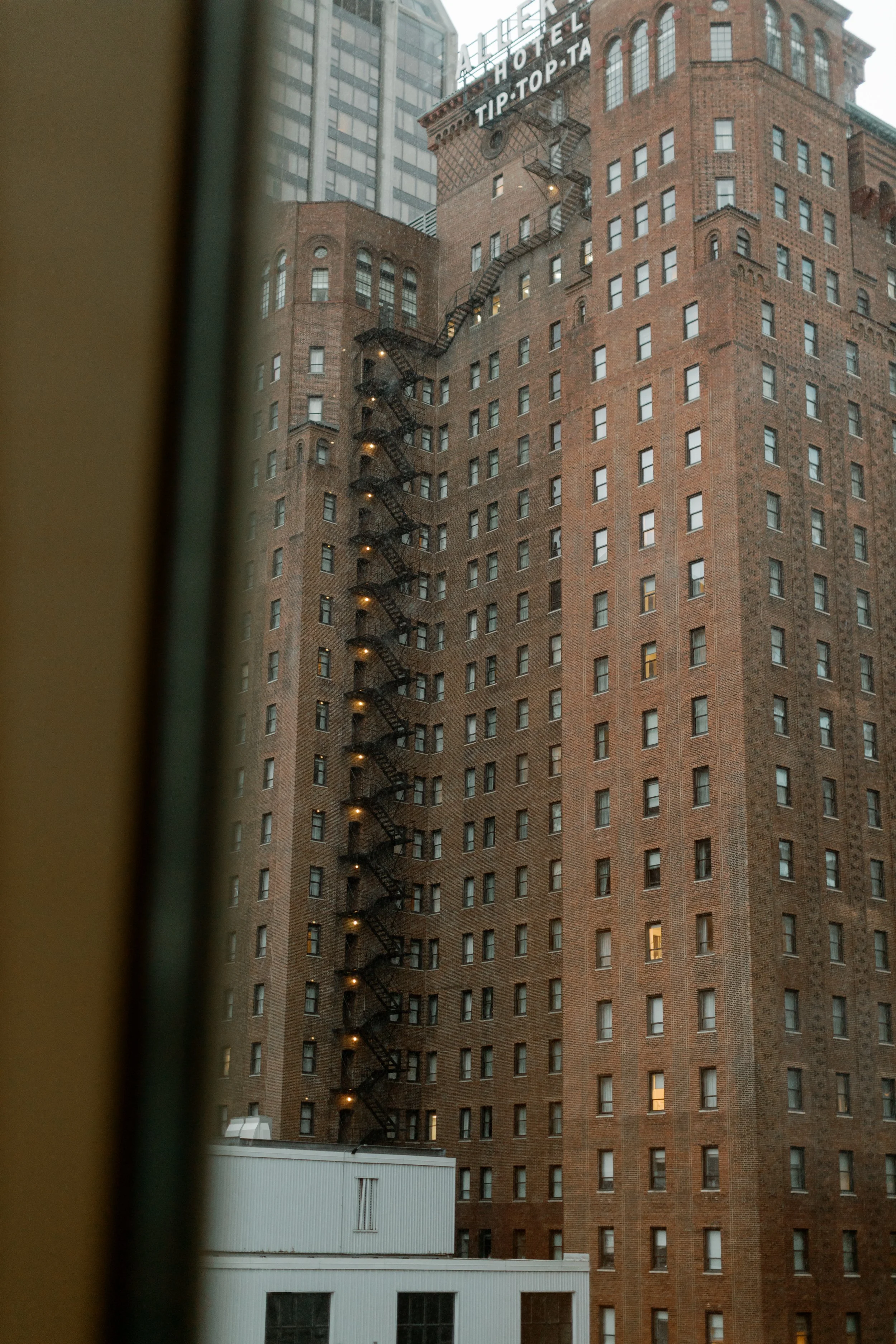 View through the Peninsula Chicago hotel window of the Allerton Hotel and its iconic red Tip Top Tap rooftop sign