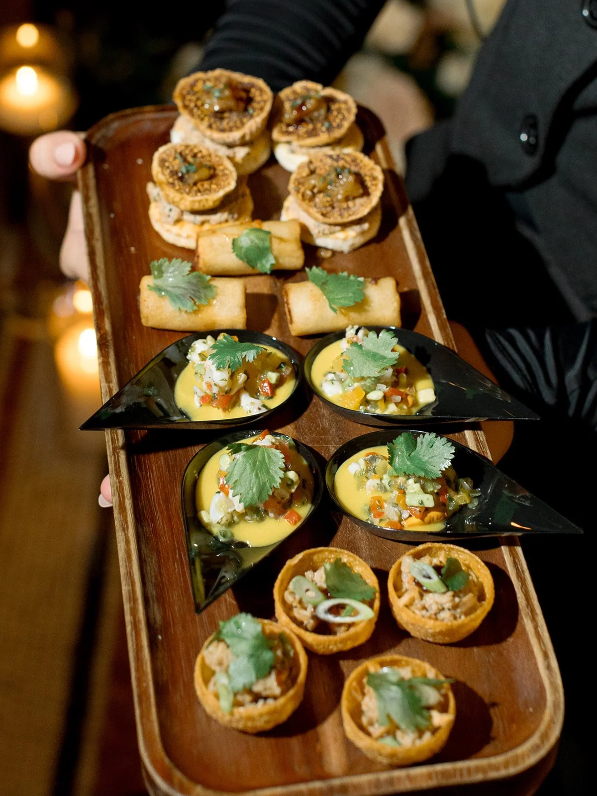 A server passing gourmet appetizers, including shrimp toast, during cocktail hour at the reception. Shot on film by a Chicago wedding photographer.