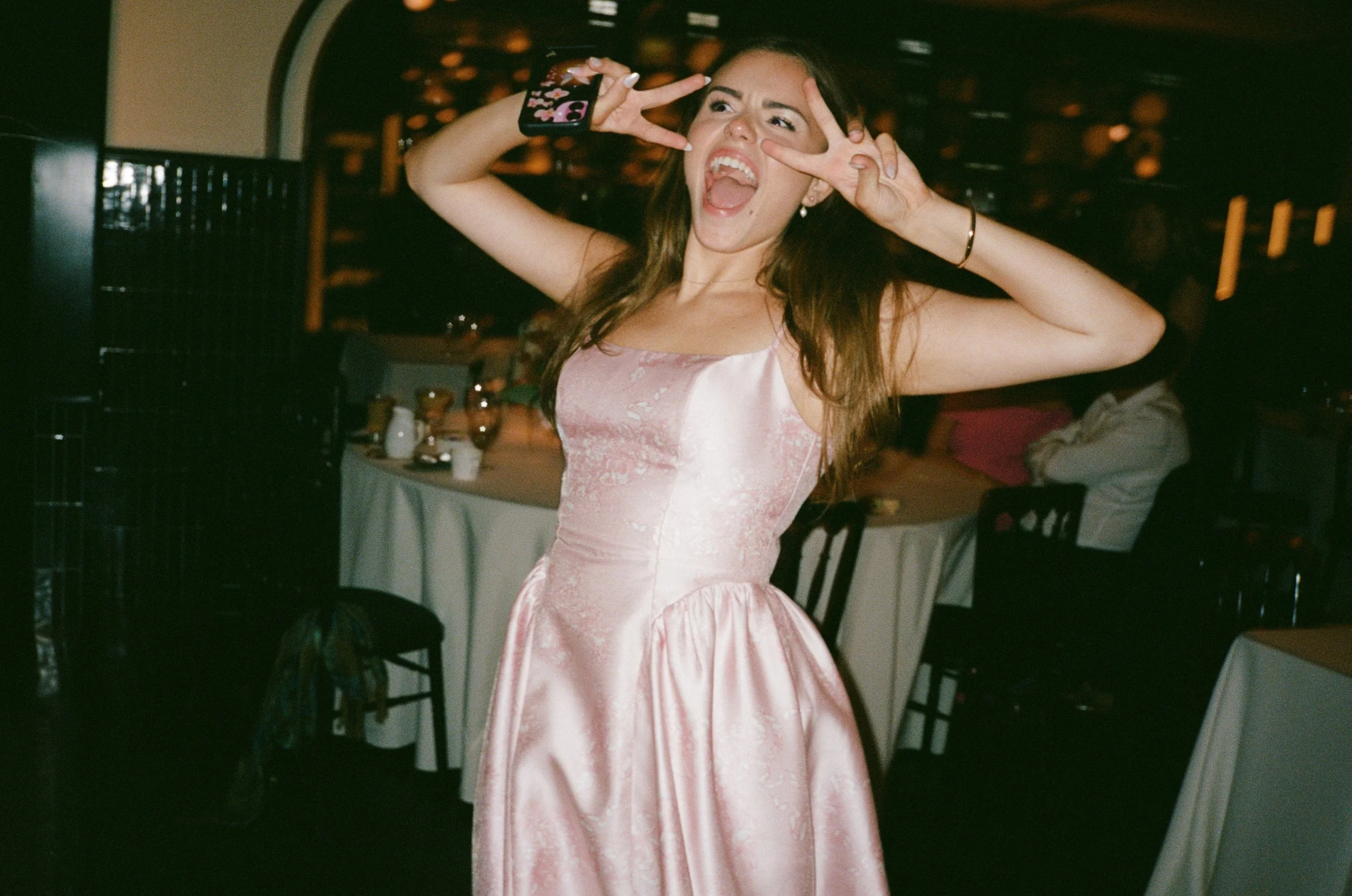 Bridesmaid strikes a playful pose on the dance floor mid celebration