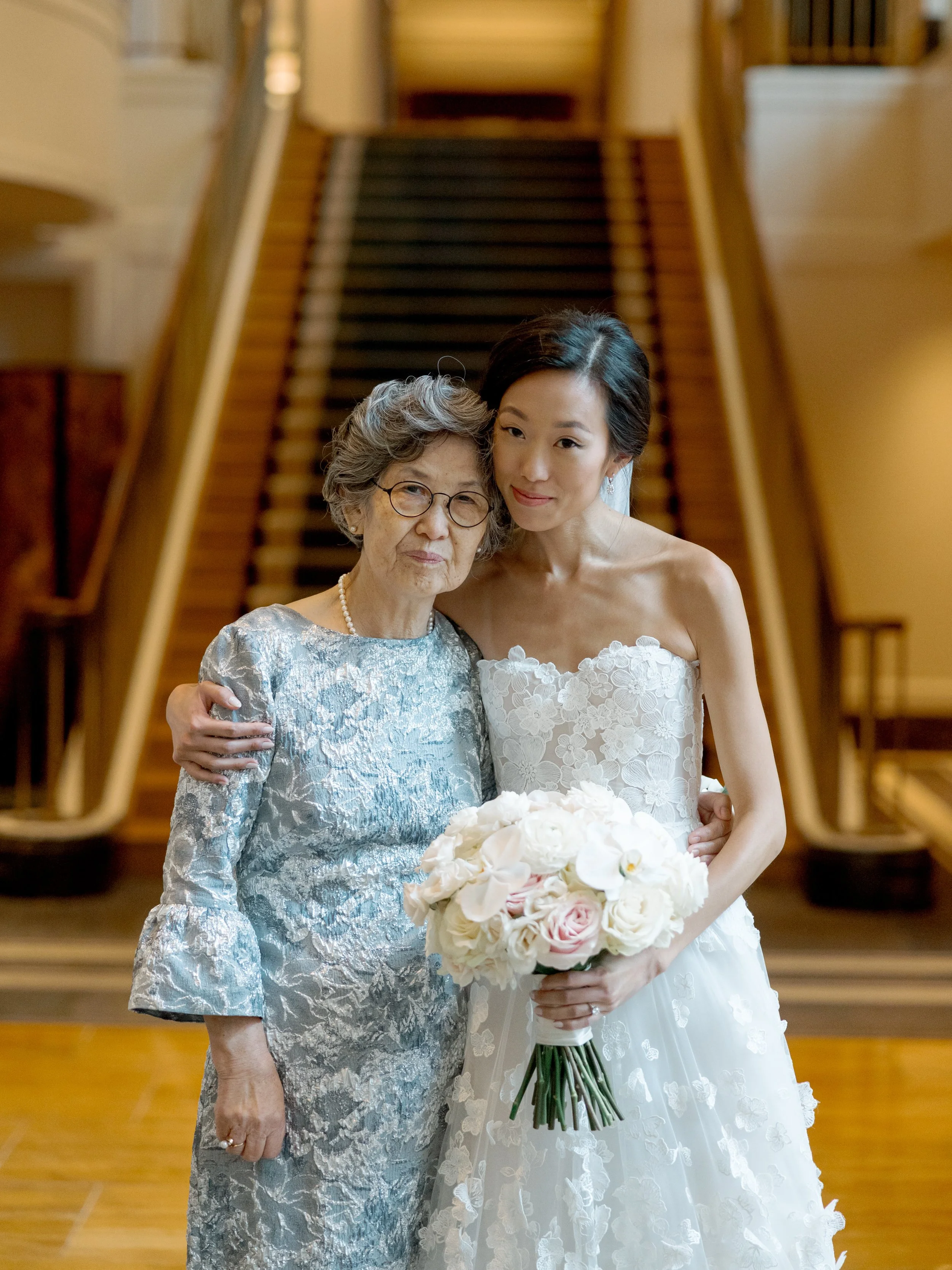Film portrait of the bride embracing her grandmother on the Peninsula Chicago grand staircase before the ceremony