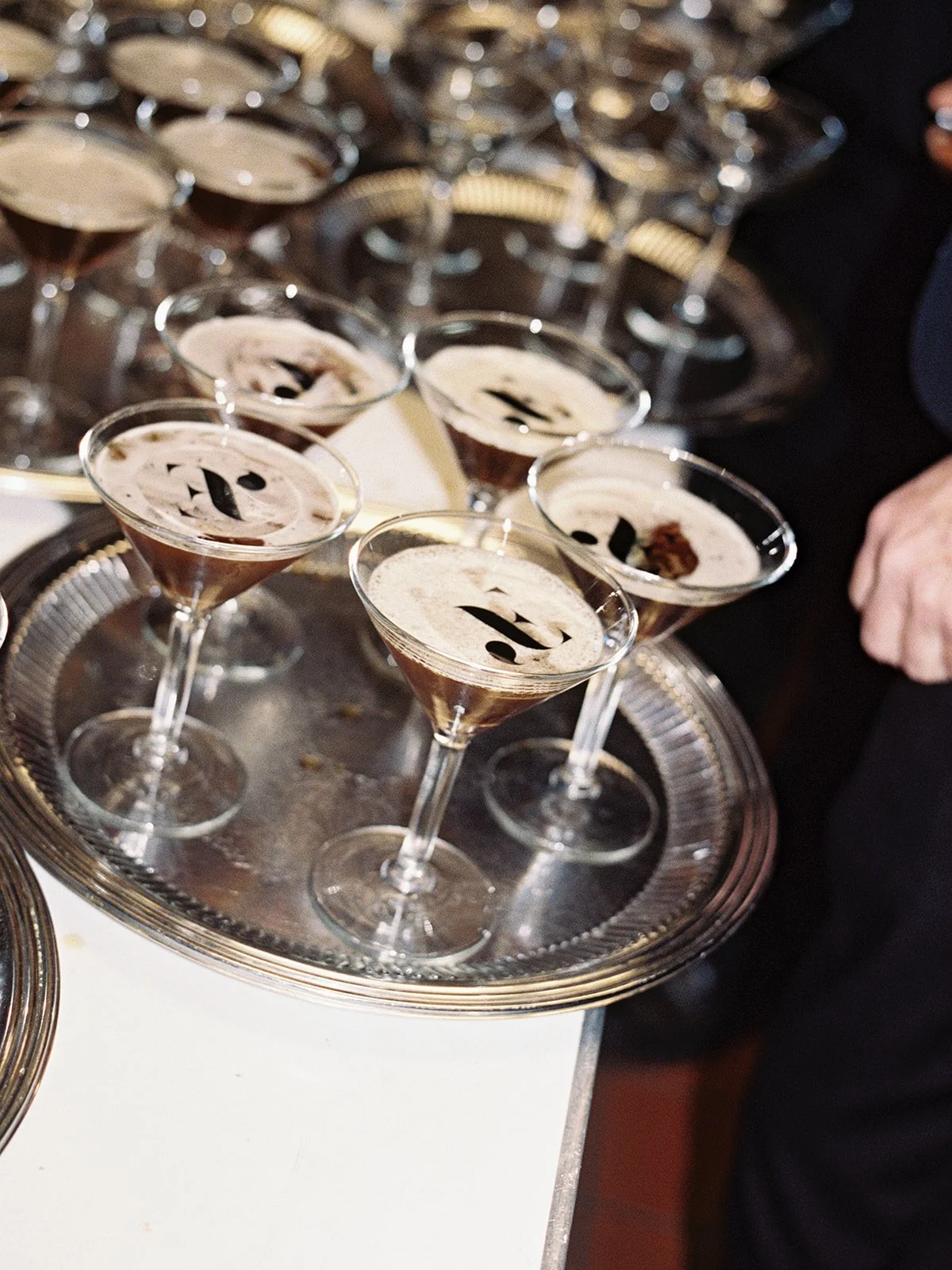 A silver tray of espresso martinis, each one crowned with monogrammed foam art, ready to be passed during cocktail hour at University Club Chicago. The kind of detail guests still talk about — captured on film by a Chicago film wedding photographer.