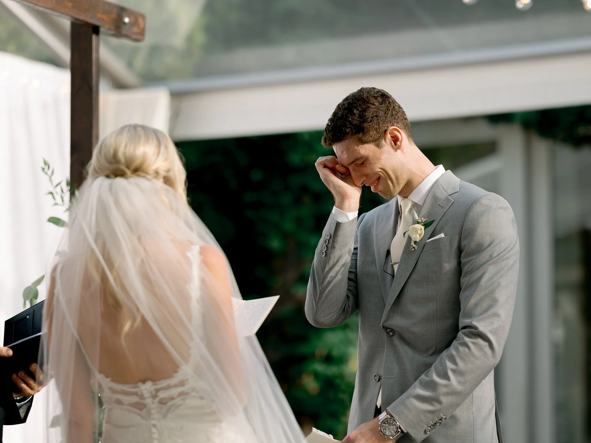 An intensely emotional ceremony moment as the groom wipes away tears while listening to his bride read her vows at the Chicago Illuminating Company.